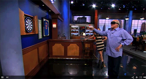 A blindfolded man throwing darts at a dartboard