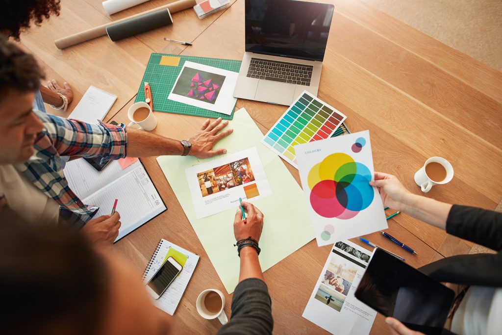 a group of graphic designers discuss the color palette for a project.